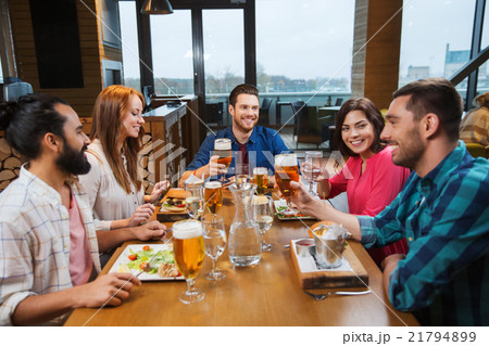 friends dining and drinking beer at restaurant 21794899