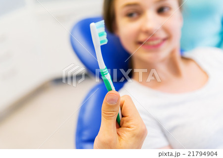 close up of dentist hand with toothbrush and girl 21794904