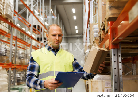man with clipboard in safety vest at warehouse 21795054