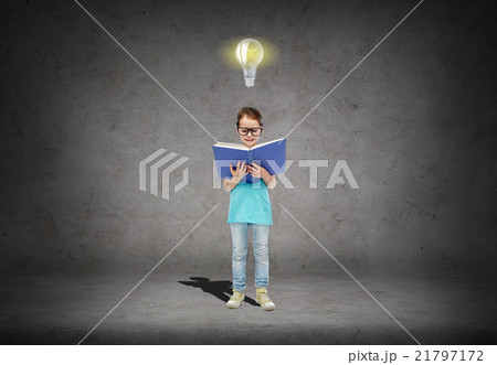 happy little girl in eyeglasses reading book 21797172