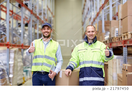 men with boxes showing thumbs up at warehouse 21797450
