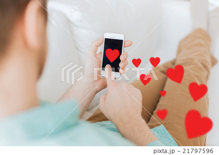 close up of man sitting with smartphone at home 21797596