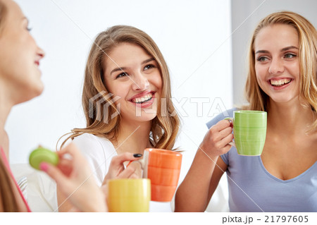 happy young women drinking tea with sweets at home happy young women drinking tea with sweets at home 21797605