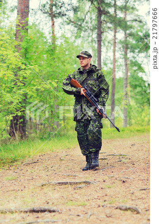 young soldier or hunter with gun in forest young soldier or hunter with gun in forest 21797666