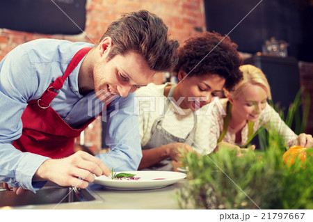 happy friends cooking and decorating dishes happy friends cooking and decorating dishes 21797667