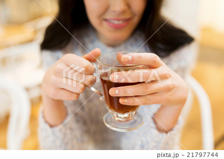 close up of happy young woman drinking tea at cafe close up of happy young woman drinking tea at cafe 21797744