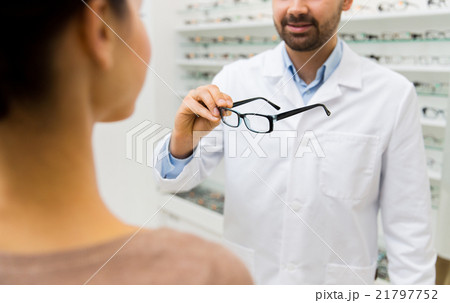 close up of optician with glasses at optics store close up of optician with glasses at optics store 21797752