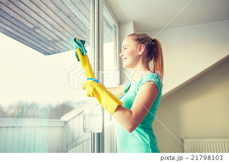 happy woman in gloves cleaning window with rag happy woman in gloves cleaning window with rag 21798103