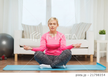 happy woman stretching leg on mat at home happy woman stretching leg on mat at home 21798354