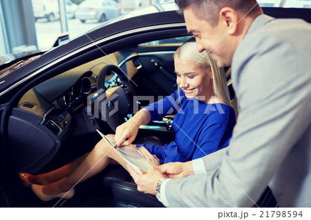 happy woman with car dealer in auto show or salon happy woman with car dealer in auto show or salon 21798594