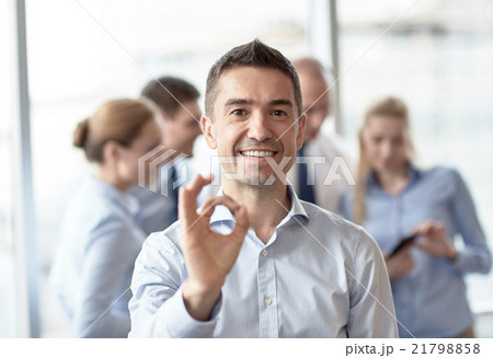 group of smiling businesspeople meeting in office 21798858