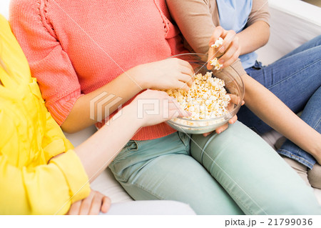 close up of teenage girls eating popcorn at home close up of teenage girls eating popcorn at home 21799036