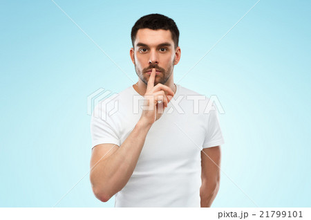 young man making hush sign over blue background 21799101