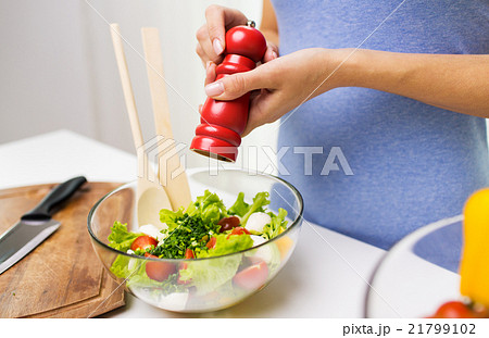 close up of woman cooking vegetable salad at home 21799102