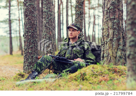 young soldier or hunter with gun in forest 21799784