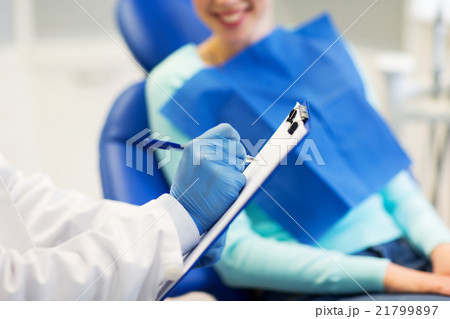 close up of dentist with clipboard and patient 21799897