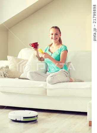 happy woman with smartphone drinking tea at home 21799898