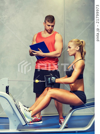 man and woman flexing muscles on gym machine 21799973