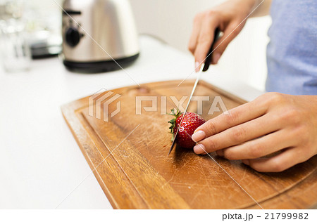 close up of woman chopping strawberry at home 21799982