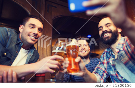 male friends with smartphone drinking beer at bar 21800156