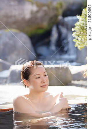 温泉の露天風呂でリラックスするミドルの女性 21800696