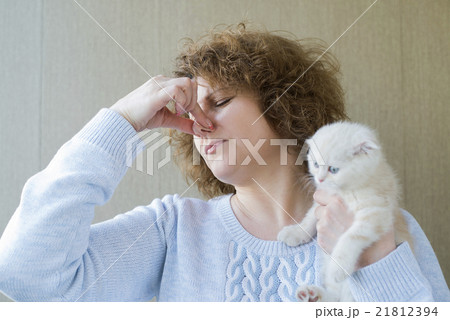 woman with allergy is holding kitten woman with allergy is holding kitten 21812394