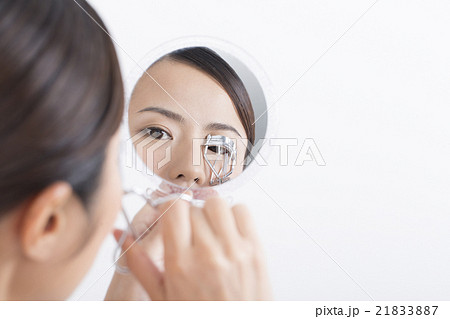 女性　美容　ビューラー　メイクアップ　鏡を持つ　白バック　コピースペース 21833887
