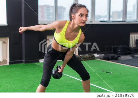 sporty woman doing work-out swinging kettlebell in sporty woman doing work-out swinging kettlebell in 21839876