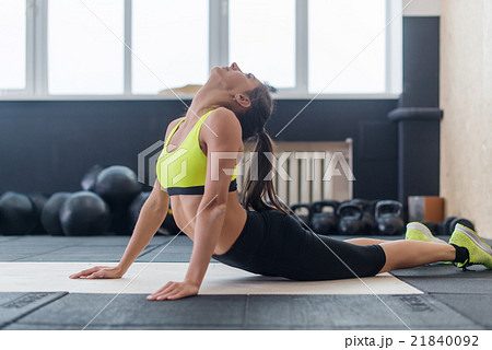 young female doing back stretching exercise, fit 21840092