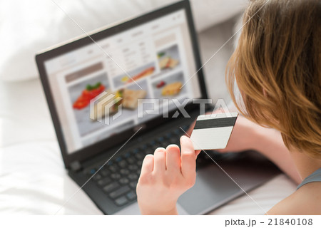 Pleasant girl holding credit card Pleasant girl holding credit card 21840108