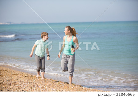 Mother with son running on the beach 21840669