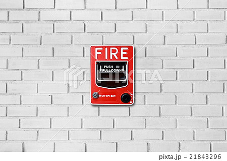 Fire alarm switch on white brick wall background Fire alarm switch on white brick wall background 21843296