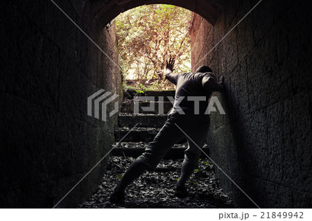 Young tired man leaves dark stone tunnel 21849942