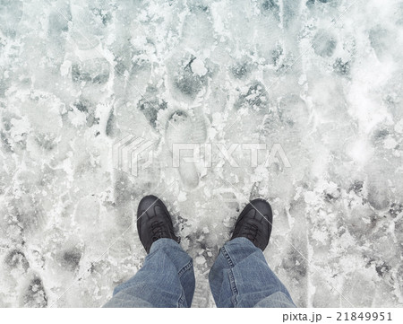 Male feet in new shoes stand on wet dirty snow 21849951