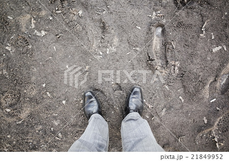 Male feet in new shoes stand on dirty rural road 21849952