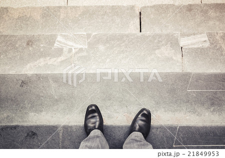 Male feet stand on outdoor stone stairs 21849953