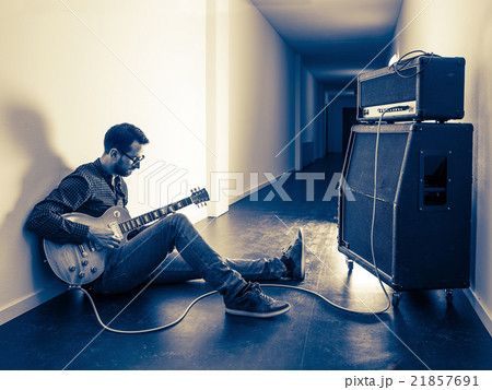 Playing his electric guitar in the hallway Playing his electric guitar in the hallway 21857691