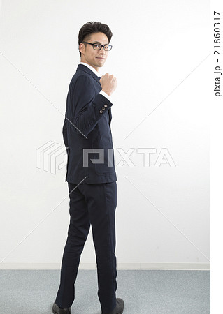 ビジネスマン ポートレート 全身 振り向く ガッツポーズ カメラ目線 表情の写真素材