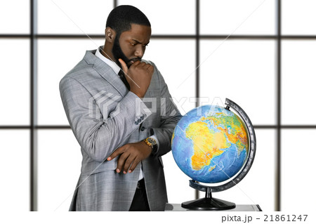 Thoughtful afro man with globe. Thoughtful afro man with globe. 21861247