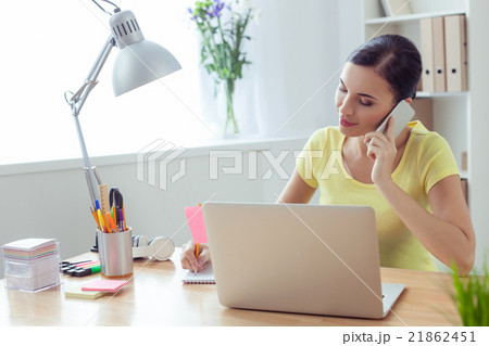 Cheerful woman is using telephone for work 21862451