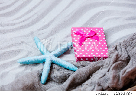 starfish, gift and fishnet on the sand 21863737