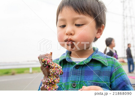 チョコバナナを食べる男の子の写真素材