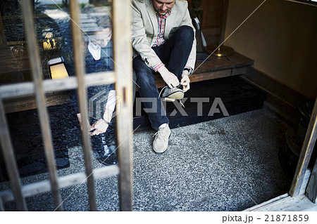 玄関で靴を履く外国人の写真素材 21871859 Pixta