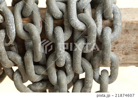 Pattern of thick rusty chain hang on wooden rail. 21874607