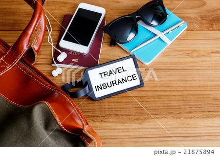 Travel insurance tag with bag on wood background 21875894
