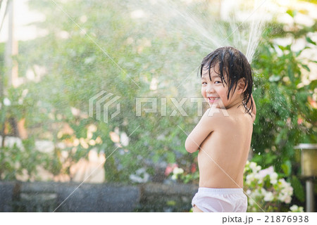 asian boy has fun playing in water from a hose asian boy has fun playing in water from a hose 21876938