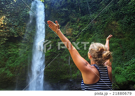 Beautiful young happy woman enjoying waterfall 21880679