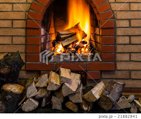stack and burning wood in indoor brick fireplace 21882841
