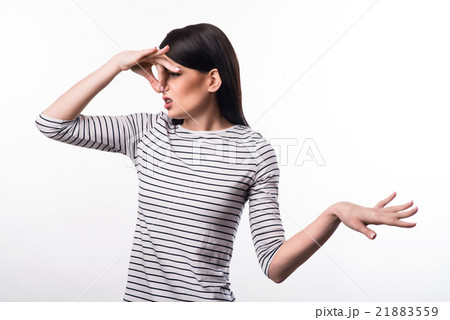 Cheerless girl closing her nose  21883559