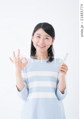 若い女性（スマートフォン、OKサイン） 21883774